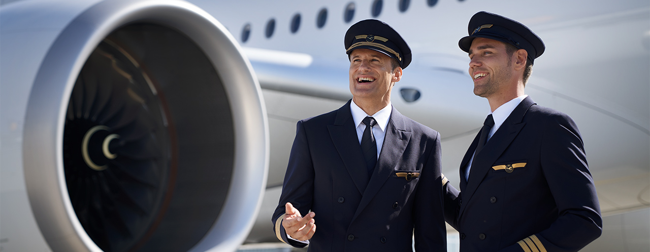 Two laughing pilots standing in front of a plane