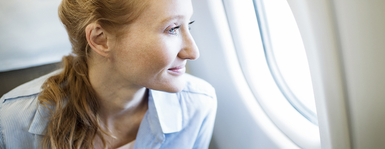 A passenger looks out the window of an airplane