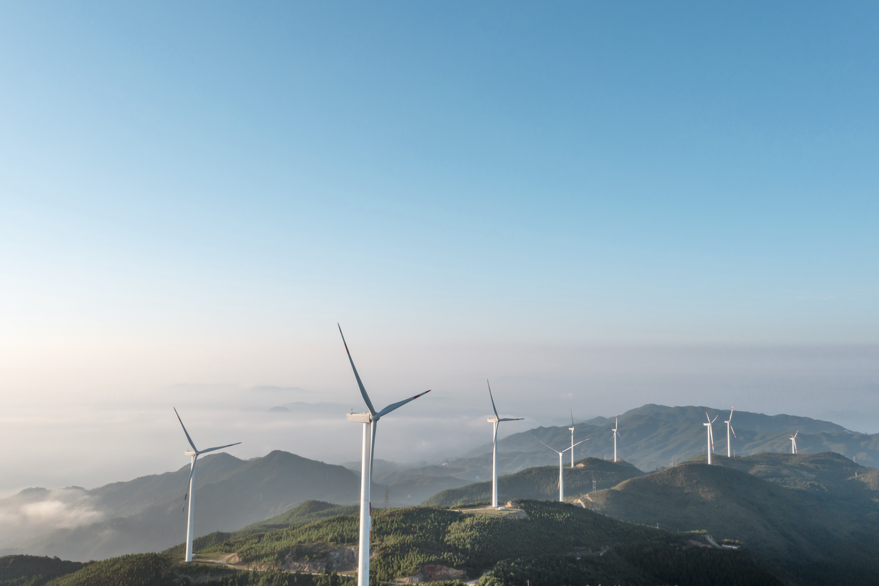 Several wind turbines stand on hills.